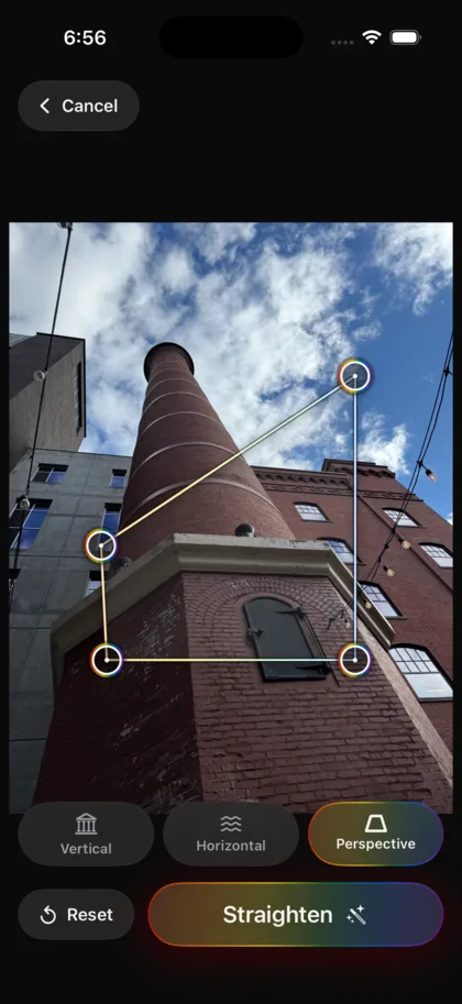 The StraightPic editor on an iPhone: a photograph of a leaning brick smokestack with four rainbow-ringed handles marking a quadrilateral on the brick wall, a row of Vertical, Horizontal and Perspective tools with the active tab in a rainbow gradient, and a rainbow-gradient Straighten button.