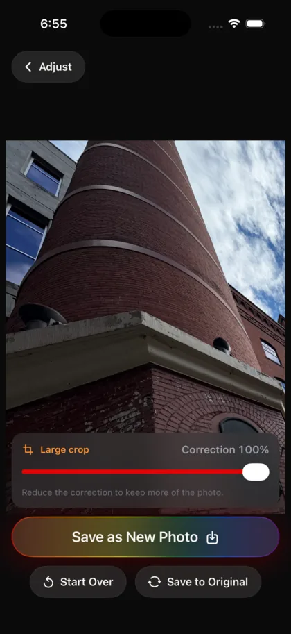 The same photograph in StraightPic after correction: the smokestack and the buildings beside it now stand upright and square to the frame, with a rainbow-gradient Save as New Photo button below.